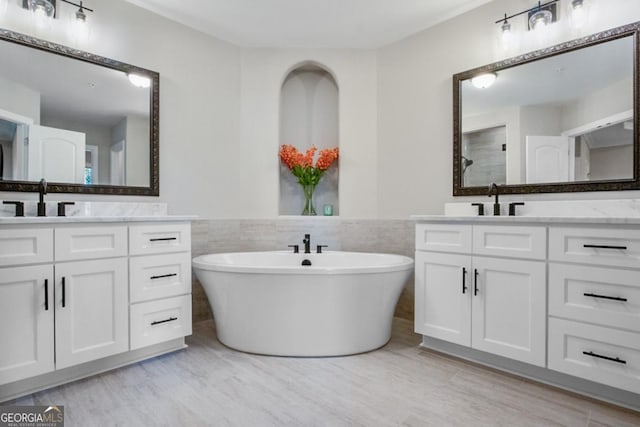 202 Via Lucca, Woodstock, GA 30188 - full bath featuring a sink, a freestanding tub, two vanities, and tile walls