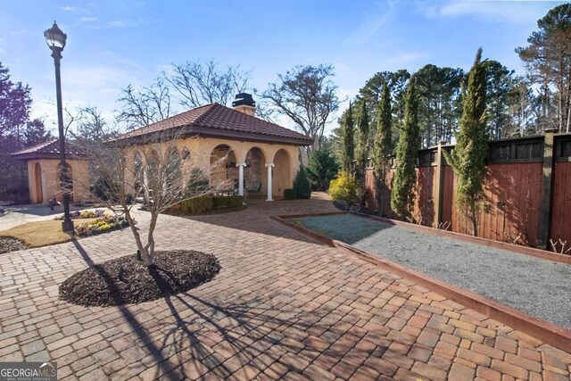 202 Via Lucca, Woodstock, GA 30188 - exterior space featuring fence, a tiled roof, a gazebo, stucco siding, and a chimney