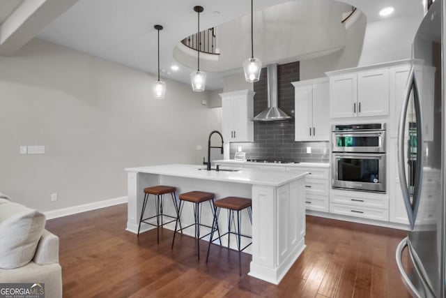 202 Via Lucca, Woodstock, GA 30188 - kitchen with a sink, decorative backsplash, stainless steel appliances, wall chimney exhaust hood, and dark wood-style flooring