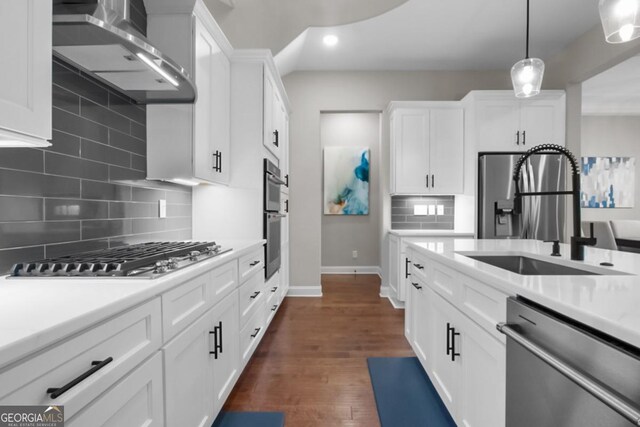 202 Via Lucca, Woodstock, GA 30188 - kitchen featuring light countertops, appliances with stainless steel finishes, white cabinets, wall chimney exhaust hood, and a sink