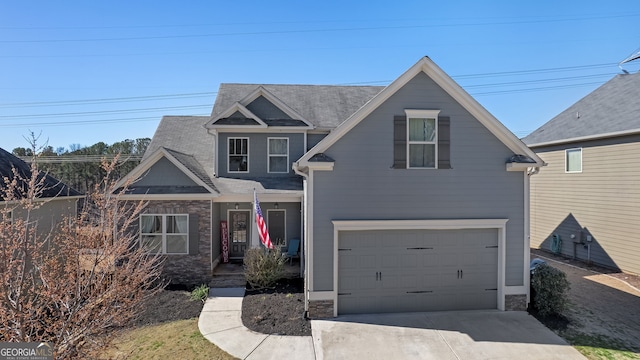 traditional home featuring concrete driveway, a garage, stone siding, and a shingled roof