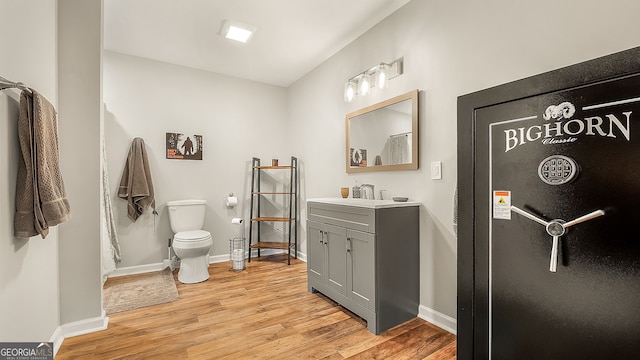 full bath featuring vanity, toilet, wood finished floors, and baseboards