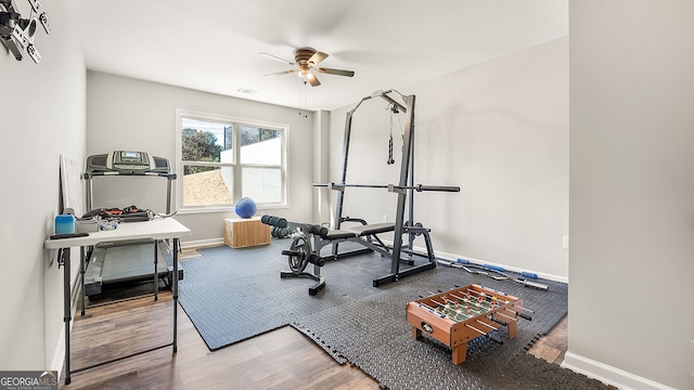 exercise area featuring visible vents, wood finished floors, baseboards, and ceiling fan