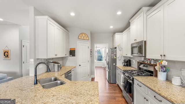 kitchen featuring dark wood-type flooring, white cabinets, appliances with stainless steel finishes, and a sink