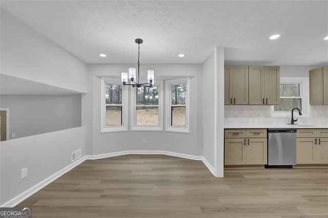 kitchen with a sink, light wood-type flooring, baseboards, and dishwasher