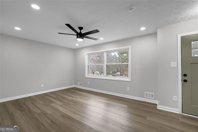 interior space featuring visible vents, baseboards, a healthy amount of sunlight, and wood finished floors