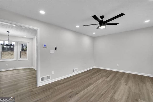 unfurnished room featuring visible vents, baseboards, and wood finished floors