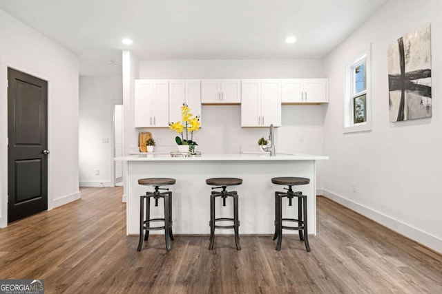 2664 Brown St NW, Atlanta, GA 30318 - kitchen featuring a breakfast bar area, dark wood-style floors, and white cabinets