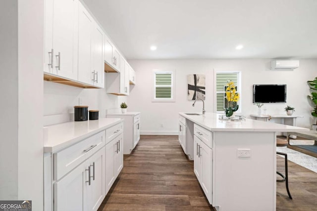 2664 Brown St NW, Atlanta, GA 30318 - kitchen with a breakfast bar, a kitchen island with sink, a sink, a wall unit AC, and dark wood-style flooring