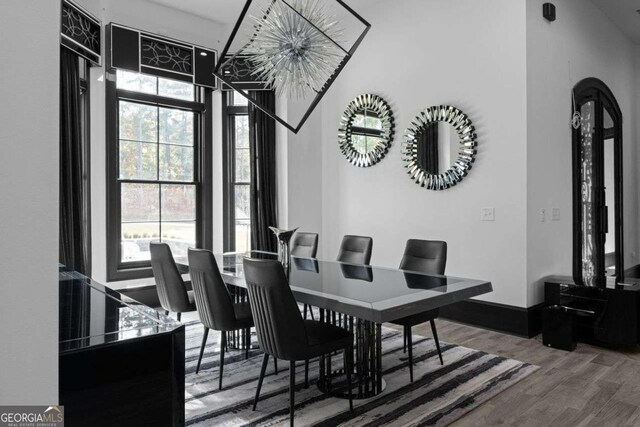 dining room featuring baseboards, a high ceiling, and wood finished floors