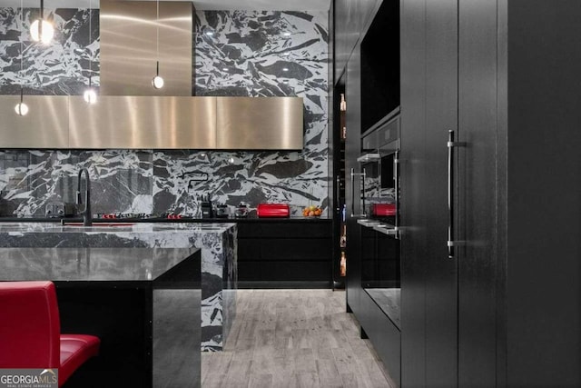 kitchen featuring a sink, extractor fan, and wood finished floors