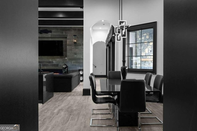 dining room with arched walkways and wood finished floors