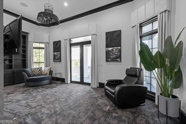 living area featuring carpet, french doors, baseboards, and ornamental molding