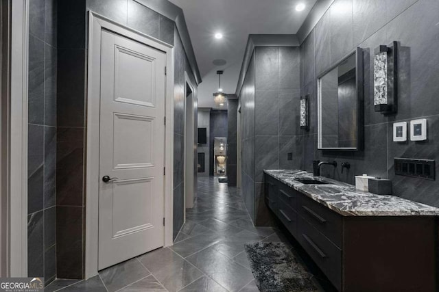 bathroom featuring recessed lighting, marble finish floor, tile walls, and vanity