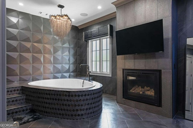 full bathroom with a tile fireplace, a garden tub, tile walls, tile patterned floors, and a chandelier