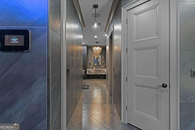 hallway featuring tile patterned floors and tile walls