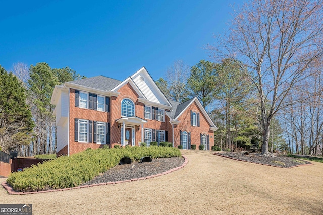 colonial inspired home featuring brick siding