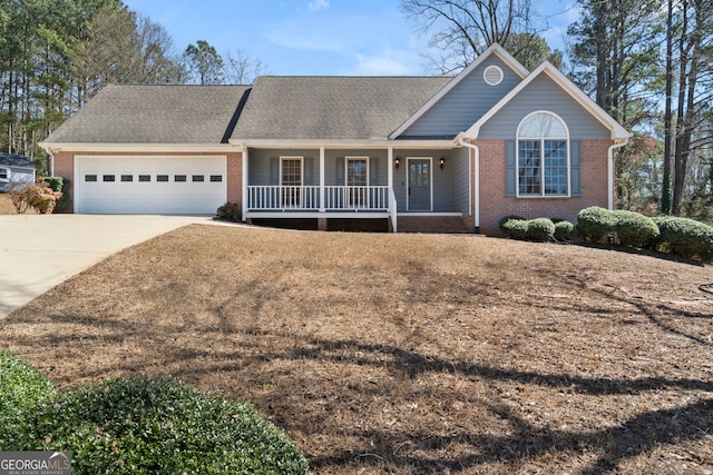 single story home with a porch, an attached garage, brick siding, and driveway