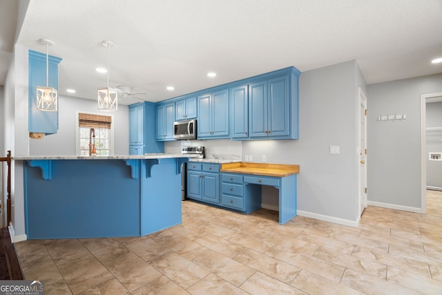 kitchen featuring blue cabinets, appliances with stainless steel finishes, a breakfast bar, and recessed lighting