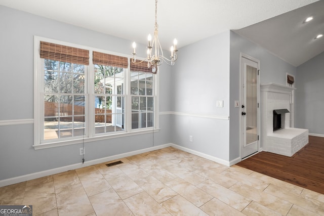 unfurnished dining area featuring a notable chandelier, baseboards, visible vents, and a wealth of natural light