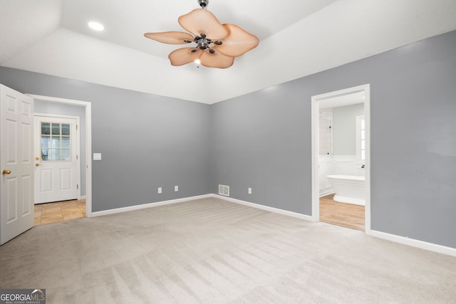 unfurnished bedroom with visible vents, carpet floors, lofted ceiling, and baseboards