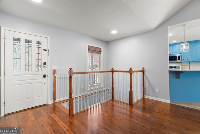 foyer featuring recessed lighting, a textured ceiling, baseboards, and wood-type flooring