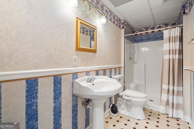 bathroom with curtained shower, wallpapered walls, a drop ceiling, a wainscoted wall, and toilet