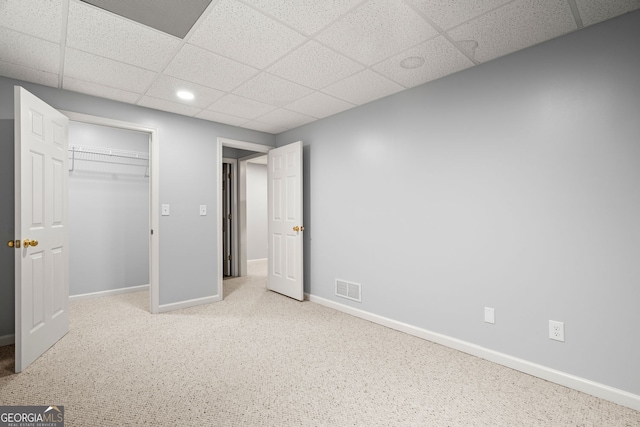 unfurnished bedroom featuring visible vents, carpet, baseboards, a closet, and a paneled ceiling