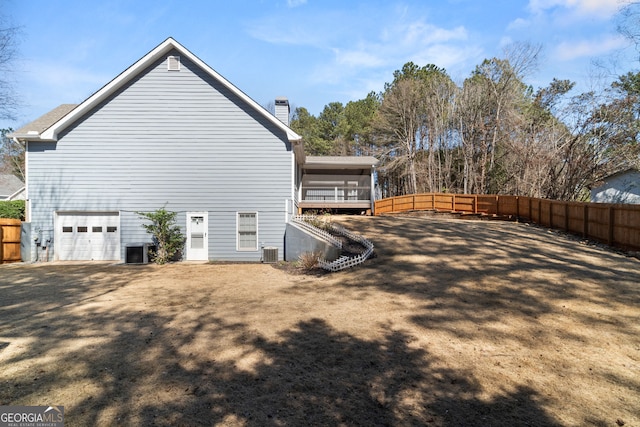 view of side of home featuring central air condition unit, a chimney, and fence