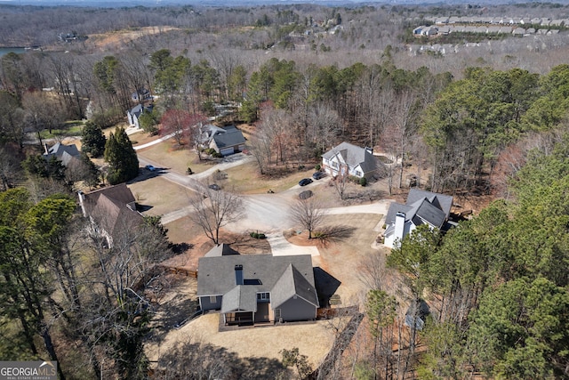 birds eye view of property featuring a forest view