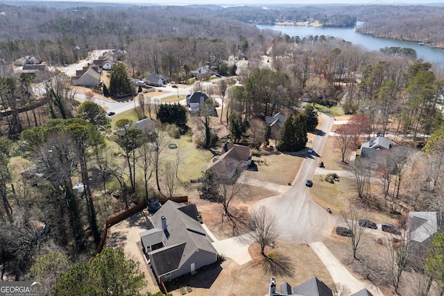 aerial view with a wooded view and a water view