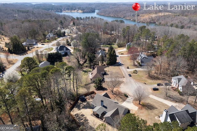 aerial view featuring a forest view and a water view