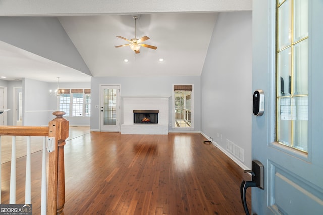 unfurnished living room featuring baseboards, visible vents, a fireplace, ceiling fan, and wood-type flooring