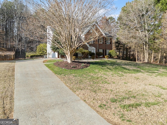 view of front facade featuring a front lawn, brick siding, a garage, and driveway