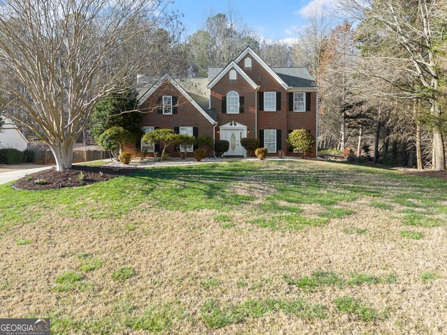 colonial house featuring brick siding and a front yard