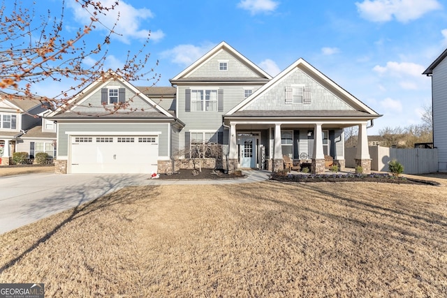 view of front of house with fence, driveway, covered porch, a front lawn, and a garage