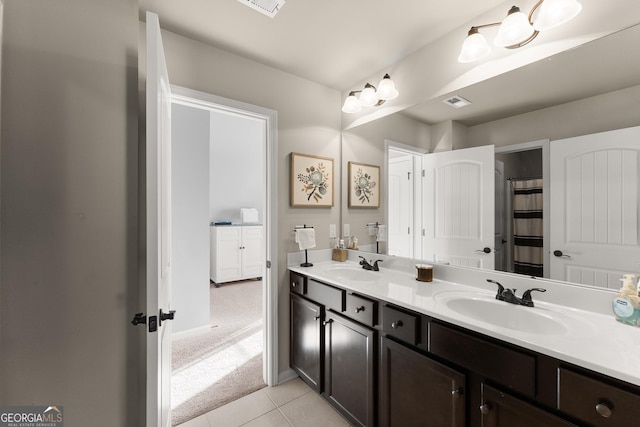 bathroom with tile patterned flooring, double vanity, visible vents, and a sink