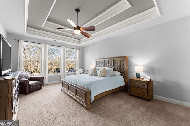 bedroom featuring baseboards, a raised ceiling, light carpet, and crown molding