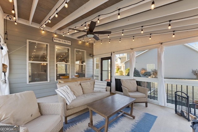 sunroom / solarium with beam ceiling, ceiling fan, and track lighting