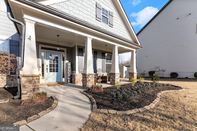 view of exterior entry with covered porch and stone siding