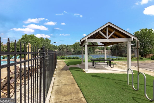 view of home's community with a swimming pool, a tennis court, a gazebo, and fence