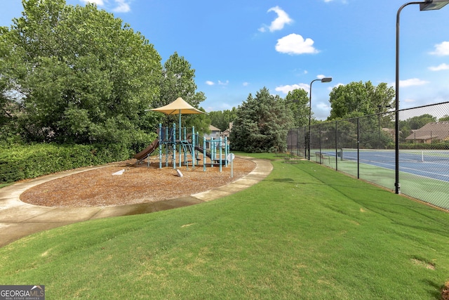 community play area featuring a lawn and fence