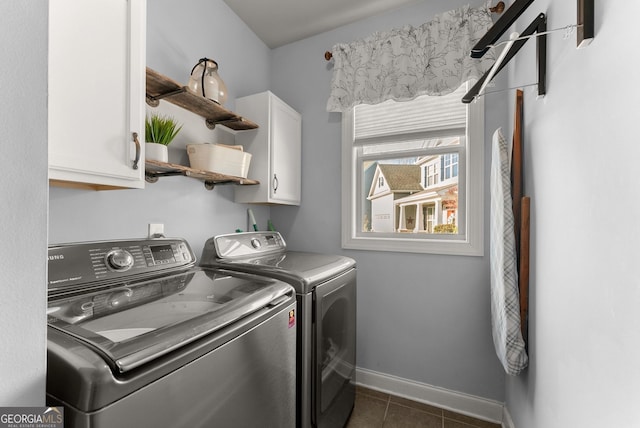 laundry room featuring baseboards, cabinet space, dark tile patterned flooring, and independent washer and dryer