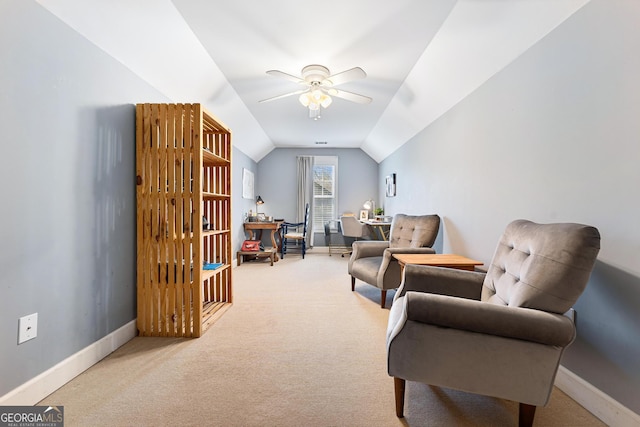 sitting room with vaulted ceiling, light colored carpet, baseboards, and ceiling fan