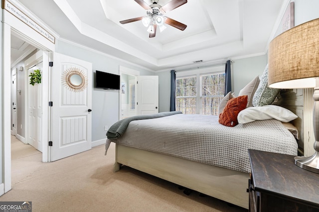 bedroom with a ceiling fan, a tray ceiling, crown molding, baseboards, and light colored carpet