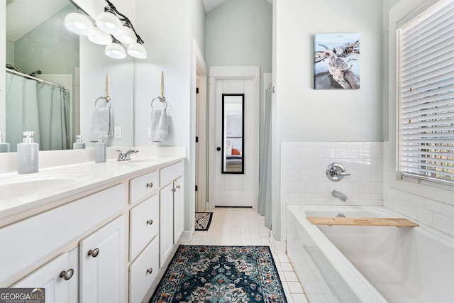 bathroom with tile patterned flooring, double vanity, a bath, and a sink