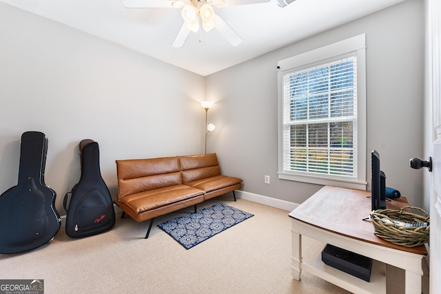 living area with baseboards, carpet, and a ceiling fan