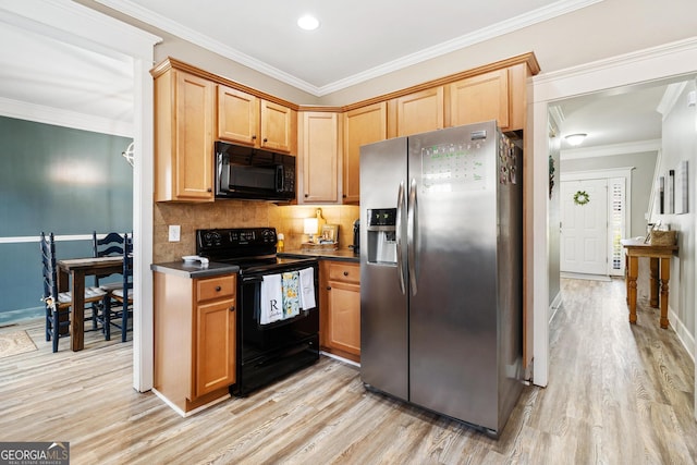 kitchen with dark countertops, light wood finished floors, tasteful backsplash, crown molding, and black appliances