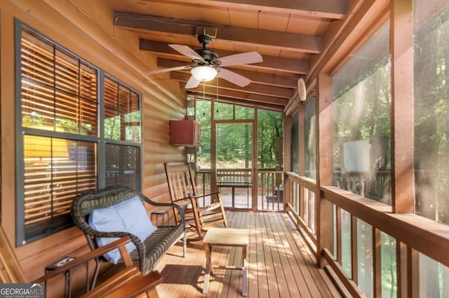 sunroom / solarium with vaulted ceiling with beams and a ceiling fan