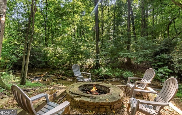 view of patio / terrace featuring a fire pit and a forest view